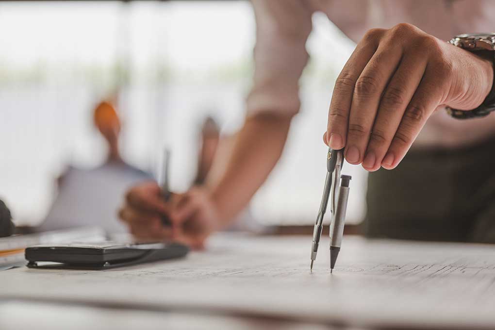 Architect using a compass to draw designs